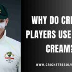 Cricket players applying white cream